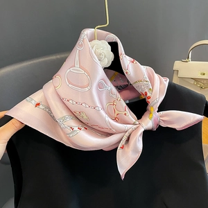 Carré en soie rose avec imprimé chaîne équestre classique suspendu à un cintre doré