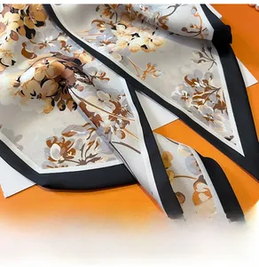 Détail d'un foulard en soie à imprimé floral vintage avec une texture lisse et bords noirs