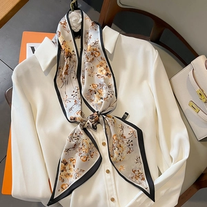 Écharpe étroite crème élégante à imprimé fleuri nouée sur un col de chemise