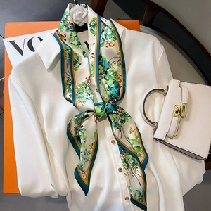 Foulard en soie à fleurs vertes sur sac à main blanc avec magazine vintage en fond