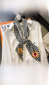 Houndstooth silk scarf with floral patterns styled on a white shirt collar as a necktie