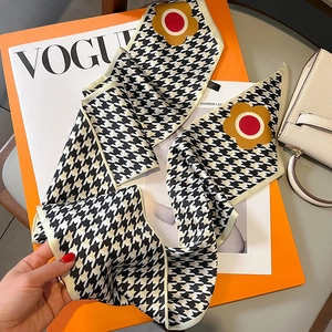 Fashionable houndstooth silk scarf with floral pattern elegantly draped over a VOGUE magazine