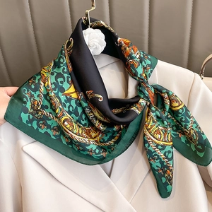 Elegant emerald and yellow silk scarf with leopard baroque print on a beige blazer