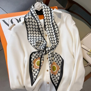 Chic houndstooth silk scarf with floral patterns styled on a white shirt collar