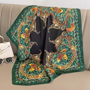 Baroque floral and leopard print silk satin square scarf draped on a beige leather sofa