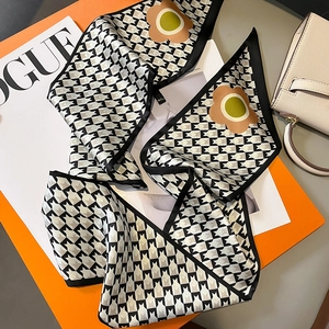 Houndstooth silk scarf with orange floral pattern displayed on a luxury handbag