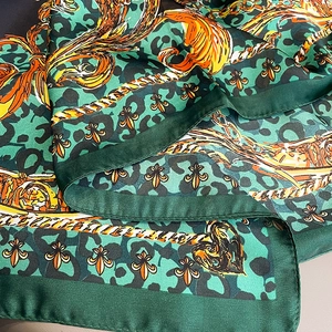 Detailed view of silky square scarf with baroque patterns, leopard print, and chain motifs