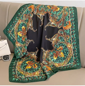 Close-up of silk square scarf with green baroque scroll patterns and leopard print details