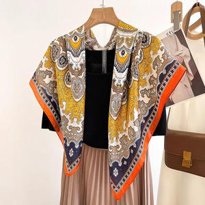 Elegant orange and blue paisley silk satin square scarf draped on a wooden hanger