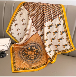 Detail of silk scarf with vintage horse print and houndstooth pattern draped on a sofa