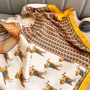 Detail of silk satin scarf with horse print and houndstooth pattern on leather background