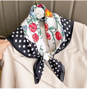 Detail of polka dot and floral silk scarf tied elegantly on a beige blazer collar