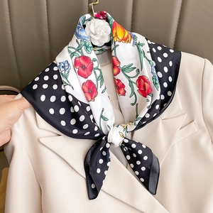 Elegant polka dot and floral silk scarf styled on a beige blazer with French Hepburn style