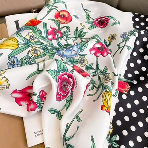 Detail showing smooth satin texture and colorful floral pattern with polka dot border