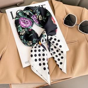 Polka dot and floral silk scarf styled on a blazer for a chic Hepburn-inspired look