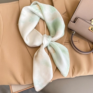 Elegant silk scarf with green ink wash gradient on a beige blazer and handbag set