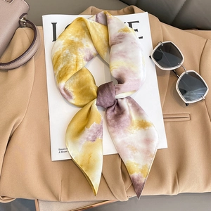 Elegant yellow and purple gradient silk scarf styled with sunglasses on a beige blazer