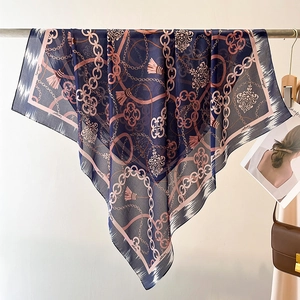 Elegant navy silk square scarf with chain pattern and tassels hung for display