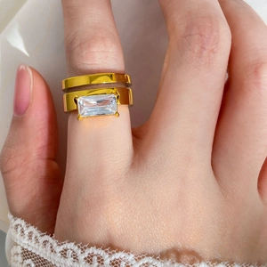 Detail of emerald cut zircon and 18K gold plated double layer rings on hand