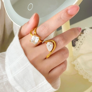 Close-up of 18K gold plated rings featuring emerald-cut and pear-shaped zircon stones