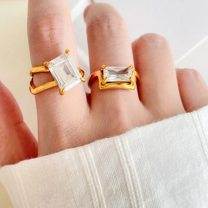 Modern 18K gold-plated rings featuring emerald-cut clear zircons on a model's hand
