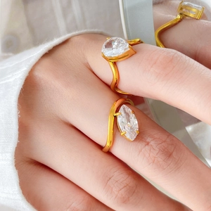 Close-up of 18K gold wave rings featuring pear-cut and marquise-cut sparkling zircons