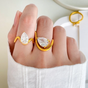 Detail of 18K gold plated rings with pear-cut cubic zirconia in wave and U-shaped designs