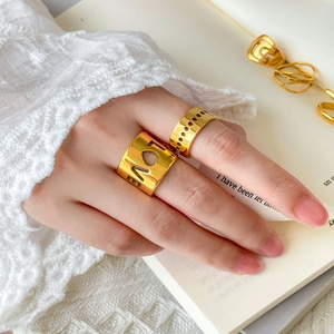 Detail of layered 18K gold plated ring featuring LOVE lettering and hollow patterns