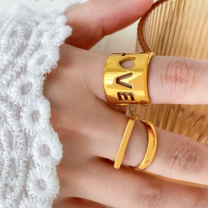 Close-up of golden multi-layer rings with hollow LOVE design and minimalist band details