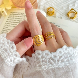 Detail of 18K gold-plated multi-layer rings with hollow wave and wrap designs