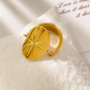 Detailed close-up of a vintage 18K gold-plated starburst engraved ring on white stone