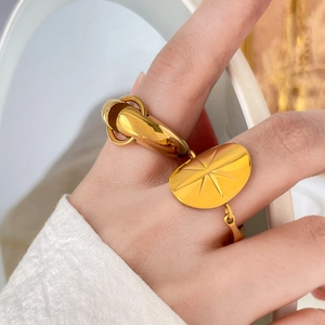 Close-up of gold titanium steel ring with an eight-pointed star and thick hoop band