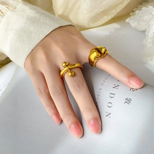 Close-up of minimalist 18K gold-plated titanium rings on hand with lace sleeve detail