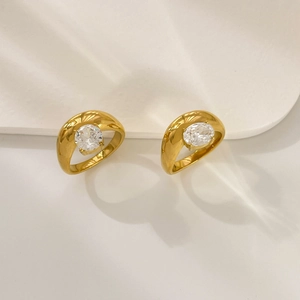 Dettaglio di anelli placcati oro 18K a fascia larga con grandi zirconi tondi e ovali