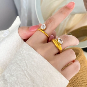 Dettaglio di anelli placcati oro 18 carati con zirconi a goccia e ovali su modella