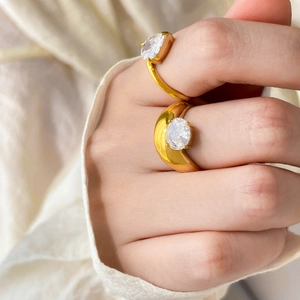 Dettaglio di anelli placcati oro con pietre di zircone a pera e ovali sulla mano