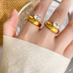 Anello largo in acciaio titanio placcato oro 18K con zircone tondo sulla mano