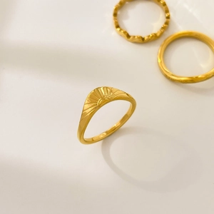 Detail von 18K vergoldeten Titanringen mit Sonnenstrahl-Textur und Wellen-Design