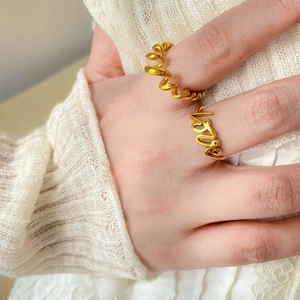 Makroaufnahme der 18K vergoldeten Ringe mit Spiralmuster und Love-Schriftzug-Design