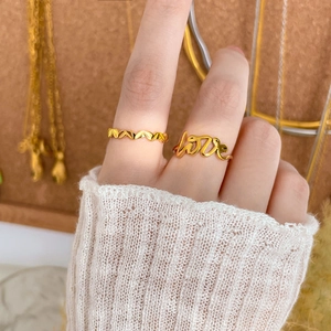 Details von 18K vergoldeten stapelbaren Ringen mit 'love' Schriftzug und Wellenmuster