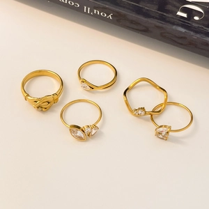 Detailed view of 5-piece gold plated ring set with marquise zircon and wave patterns