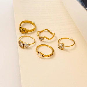 Five-piece 18K gold plated ring set with zircon accents on vintage book pages