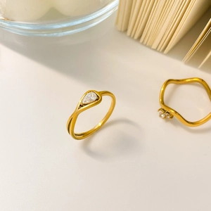Detail of 18K gold-plated titanium ring with teardrop zircon and wavy gemstone band