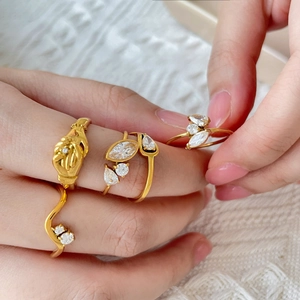 Set of four 18K gold plated titanium rings with zircon eye and wave patterns on lace