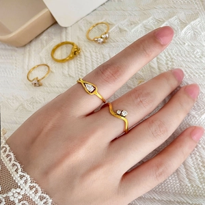 Detail shot of multi-style gold rings set with cubic zirconia on elegant lace background