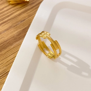 Detail of 18K gold-plated titanium multi-layer curved leaf ring on a white tray