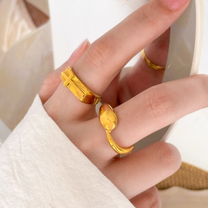 Detail shot of 18K gold plated titanium rings featuring cross relief and leaf textures