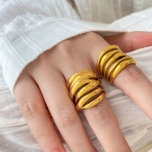 Close-up of chunky multi-layer curved rings in 18K gold plated finish on finger