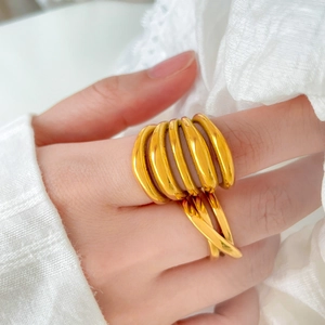 Detail of 18K gold-plated multi-layer and criss-cross minimalist rings on a model hand