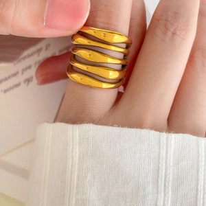 Close-up of a multi-layer wrapped 18K gold-plated ring with wavy texture on model's hand